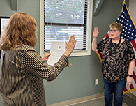  District information specialist and notary Shellie Scobee swears in new board member Mary Powell.